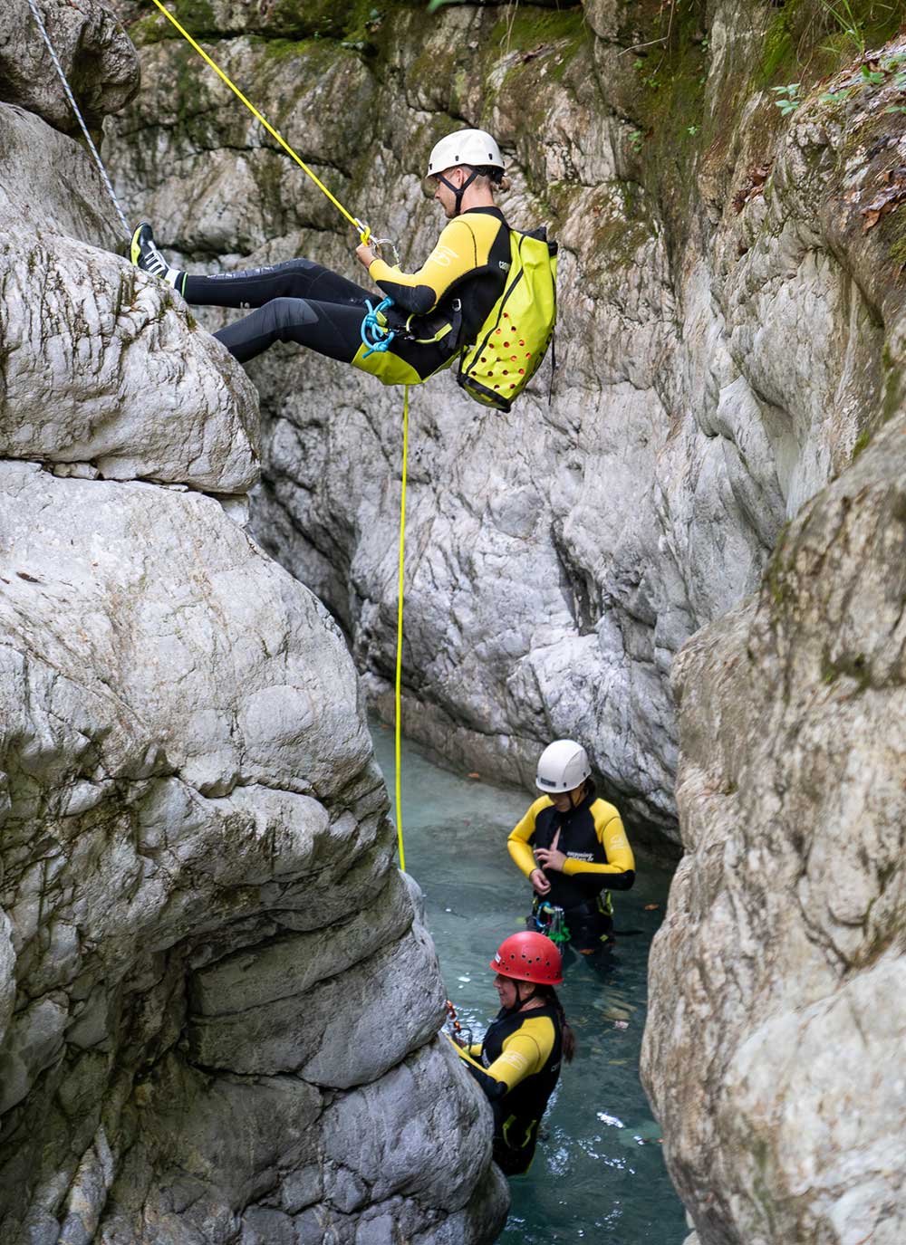 Person seilt sich beim Canyoning an einem Wasserfall ab